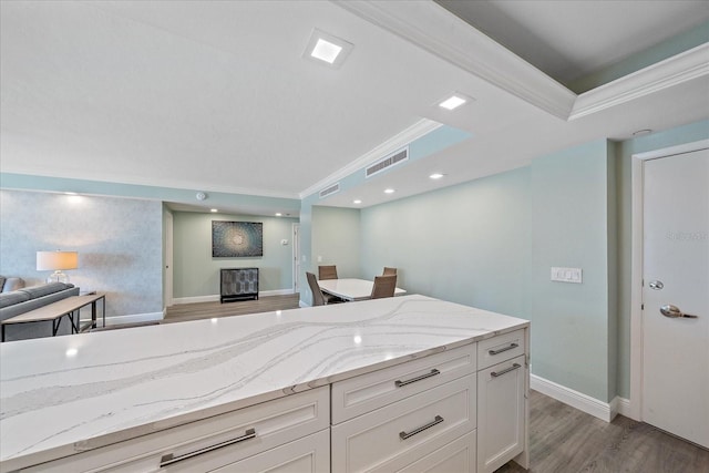 1212 Benjamin Franklin Dr Unit 306, Sarasota, FL 34236 - kitchen with open floor plan, crown molding, light wood finished floors, light stone countertops, and white cabinetry