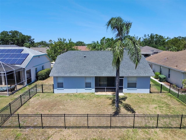 rear view of house with roof with shingles, stucco siding, a lawn, and a fenced backyard