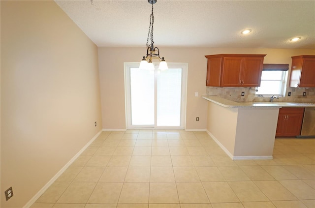 2521 Tamarind Dr, Edgewater, FL 32141 - kitchen with decorative backsplash, a peninsula, light countertops, stainless steel dishwasher, and hanging light fixtures