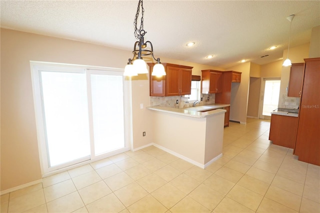 2521 Tamarind Dr, Edgewater, FL 32141 - kitchen featuring a sink, brown cabinets, decorative backsplash, a peninsula, and light countertops