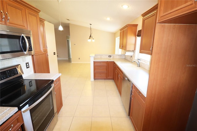 2521 Tamarind Dr, Edgewater, FL 32141 - kitchen featuring brown cabinets, a sink, stainless steel appliances, light countertops, and vaulted ceiling