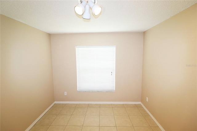 2521 Tamarind Dr, Edgewater, FL 32141 - spare room featuring light tile patterned flooring, a healthy amount of sunlight, a notable chandelier, and baseboards
