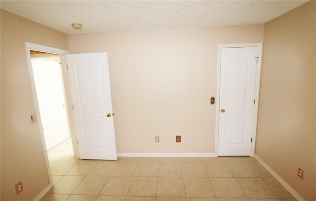 2521 Tamarind Dr, Edgewater, FL 32141 - empty room with baseboards, a textured ceiling, and light tile patterned flooring
