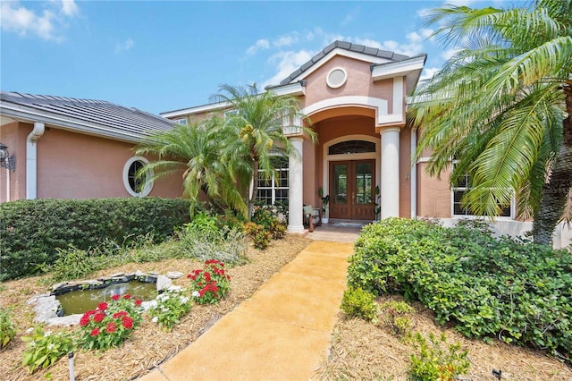 entrance to property with french doors and stucco siding