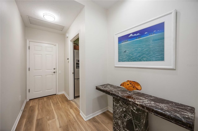 doorway to outside featuring light wood-style flooring and baseboards