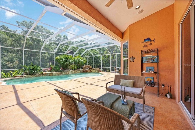 outdoor pool with ceiling fan, a patio area, and glass enclosure