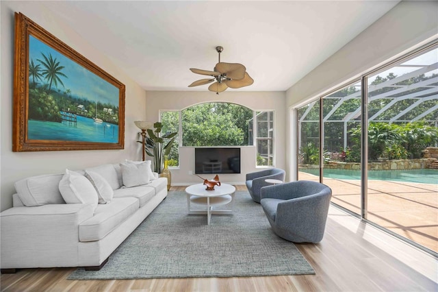 living room with a sunroom, wood finished floors, and a ceiling fan