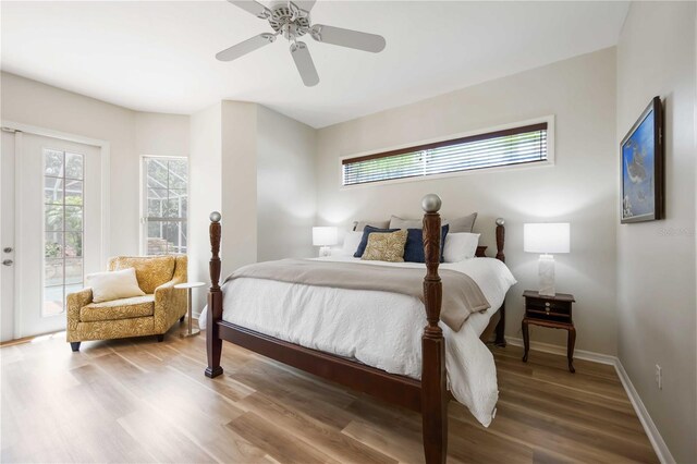 bedroom with access to exterior, wood finished floors, baseboards, and a ceiling fan