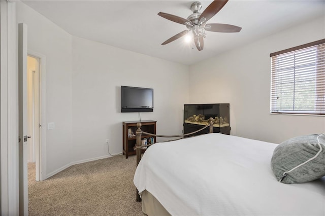bedroom with light colored carpet, baseboards, and ceiling fan