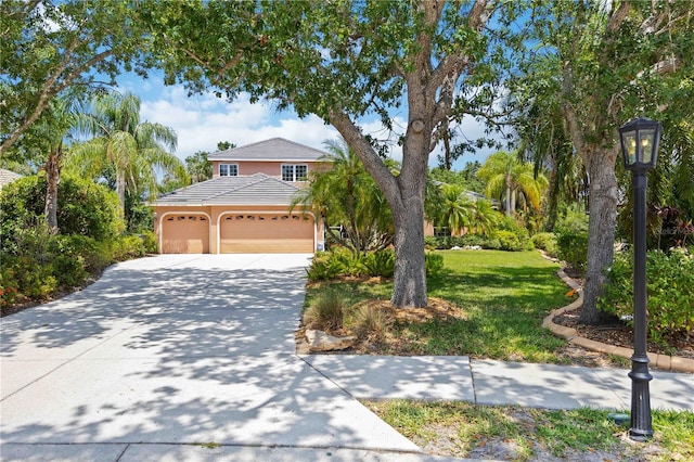 view of front of home featuring concrete driveway, an attached garage, a front lawn, and a tiled roof