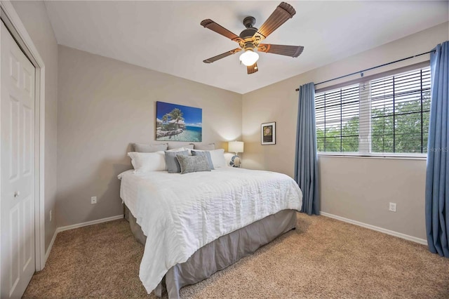 carpeted bedroom featuring baseboards, a closet, and ceiling fan