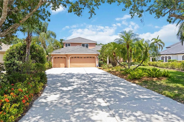 view of front of property with concrete driveway, a garage, and stucco siding