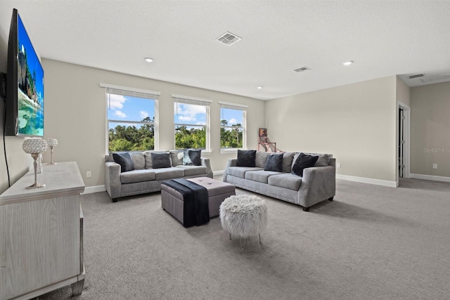 carpeted living room featuring baseboards, a wealth of natural light, and visible vents