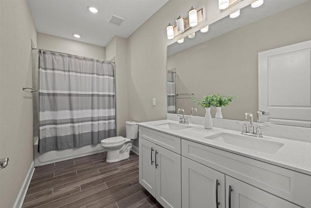 full bath with a sink, toilet, wood finished floors, and visible vents