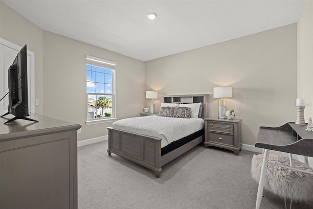 bedroom featuring baseboards and light colored carpet