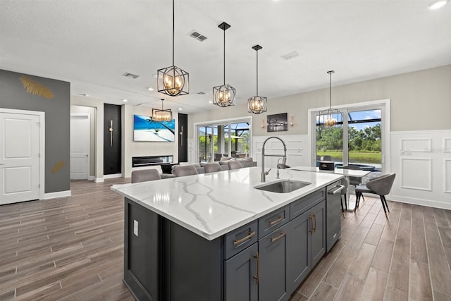 kitchen featuring a chandelier, visible vents, a sink, and wood finished floors