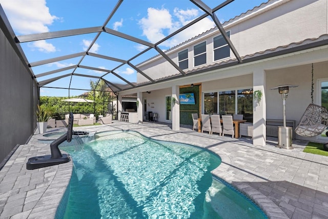 view of pool featuring a pool with connected hot tub, outdoor lounge area, a lanai, and a patio area