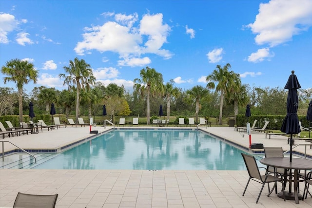 community pool with fence and a patio area
