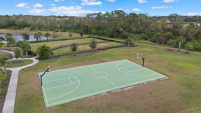 view of basketball court with a lawn, a water view, fence, and community basketball court