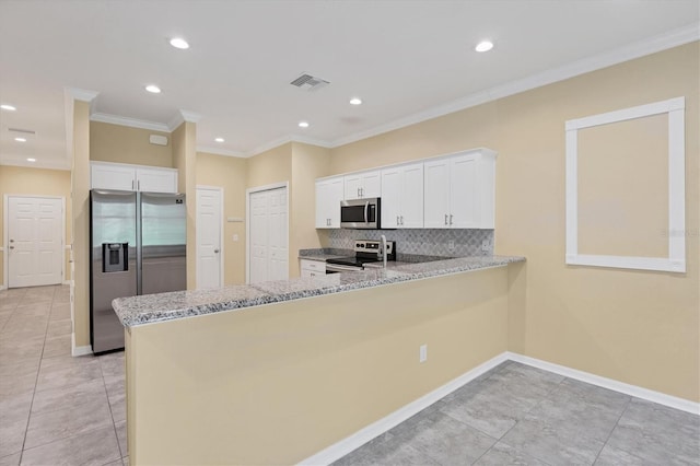 kitchen with decorative backsplash, stainless steel appliances, white cabinets, and visible vents