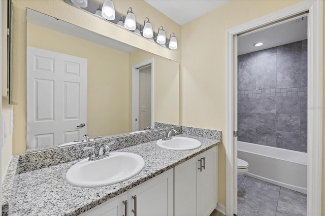 bathroom featuring double vanity, toilet, a sink, and tile patterned flooring