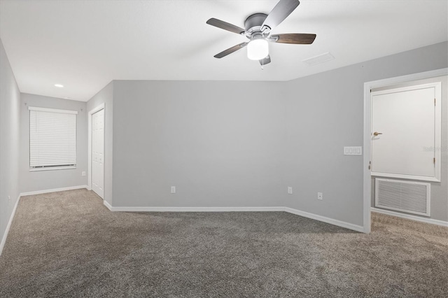 carpeted empty room featuring a ceiling fan, baseboards, and visible vents