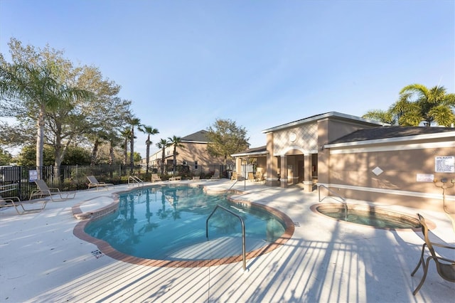 pool with a patio and fence