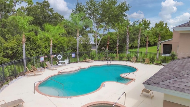 community pool with fence and a patio area