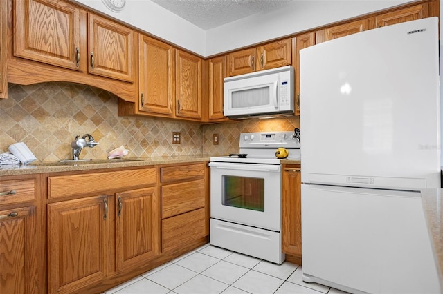 kitchen featuring brown cabinetry, light countertops, white appliances, and tasteful backsplash