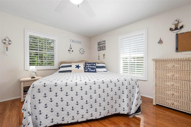 bedroom featuring baseboards, ceiling fan, and wood finished floors