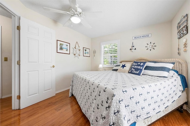 bedroom with baseboards, ceiling fan, and wood finished floors