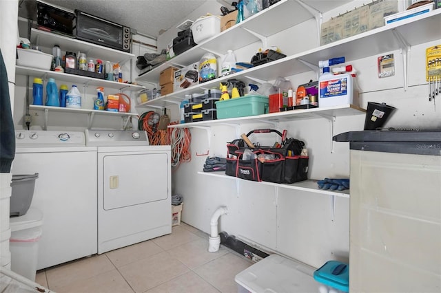 washroom featuring laundry area, washing machine and dryer, and light tile patterned floors