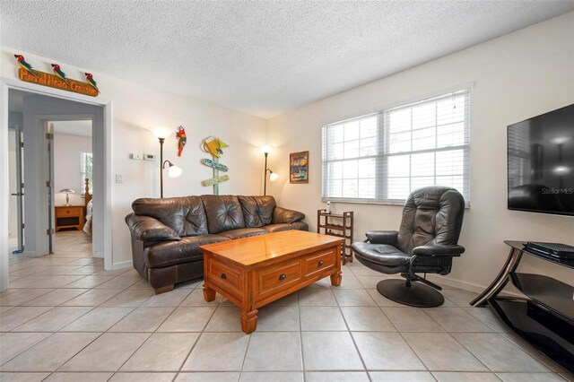 living area with a textured ceiling and light tile patterned floors