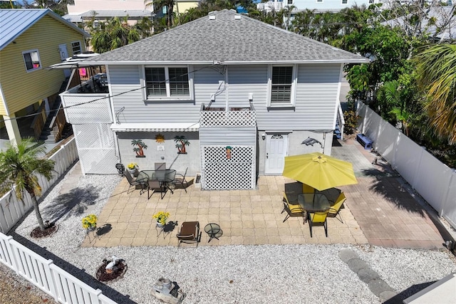 back of house featuring a patio, a shingled roof, and a fenced backyard