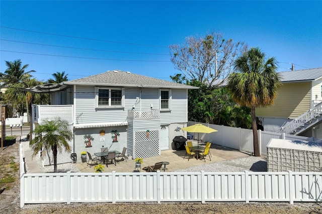 rear view of property with a fenced backyard, outdoor dining area, and a patio area