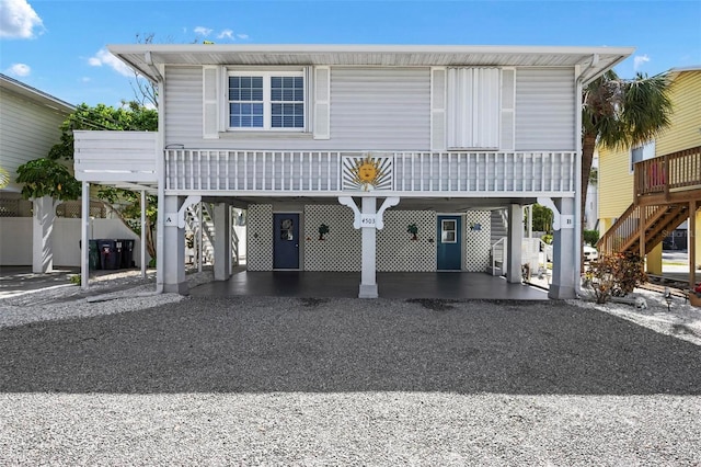 coastal inspired home featuring stairway, driveway, and a carport
