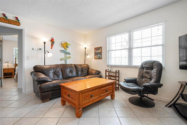 living area featuring a textured ceiling and light tile patterned floors