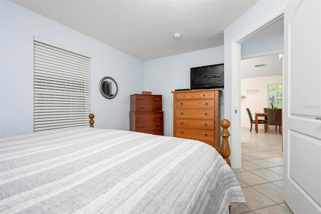 bedroom featuring light tile patterned floors, a textured ceiling, and visible vents