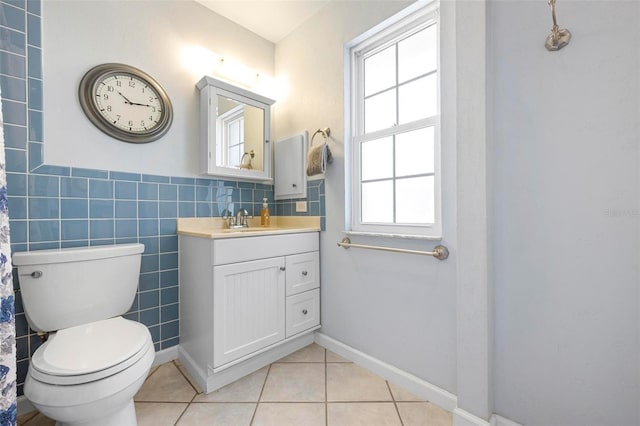 full bath with tile walls, tile patterned floors, a wainscoted wall, vanity, and toilet