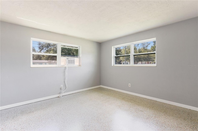 4229 Alna Way, Sarasota, FL 34232 - unfurnished room with speckled floor, baseboards, cooling unit, and a textured ceiling