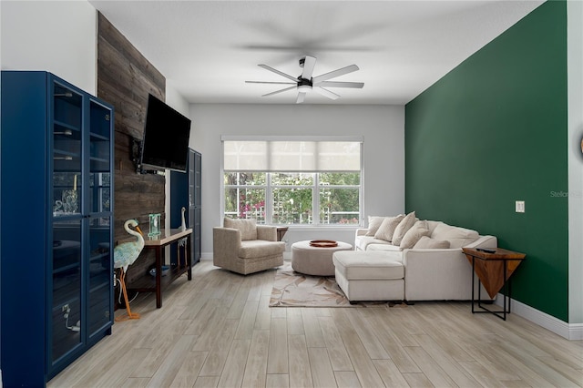 living room featuring ceiling fan, light wood-style flooring, and baseboards