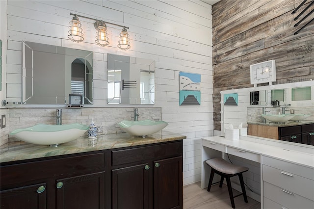 bathroom with wood walls and a sink