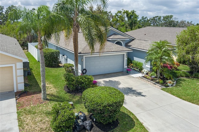 view of front facade with concrete driveway, a front yard, stucco siding, and an attached garage