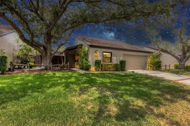 ranch-style home with fence, a garage, stucco siding, a front yard, and concrete driveway