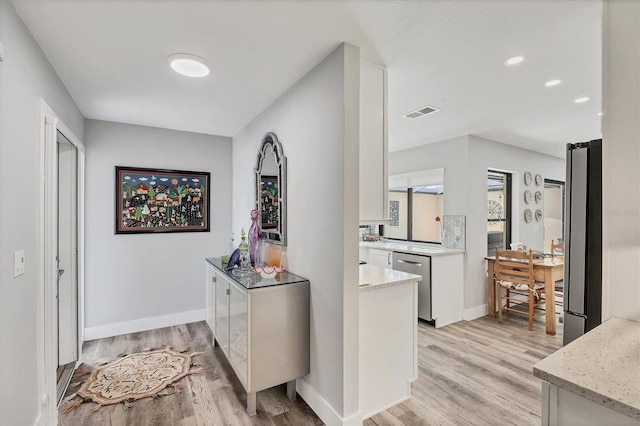 hall with baseboards, recessed lighting, and light wood finished floors