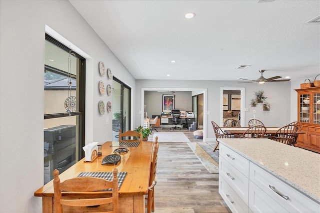 kitchen with light stone countertops, light wood-style floors, white cabinetry, recessed lighting, and a ceiling fan