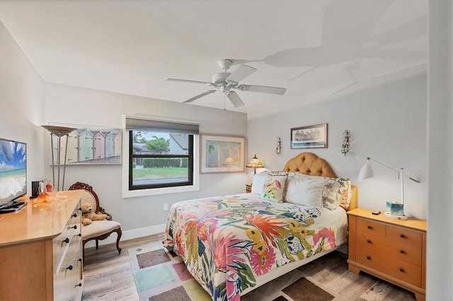 bedroom featuring light wood-style floors, baseboards, and ceiling fan