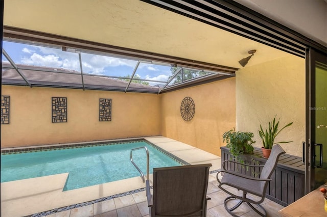 outdoor pool featuring a patio and glass enclosure