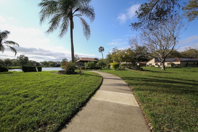 view of property's community with a lawn and a water view