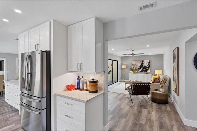 3955 Glen Oaks Manor Dr, Sarasota, FL 34232 - kitchen with stainless steel fridge with ice dispenser, wood finished floors, white cabinets, ceiling fan, and open floor plan